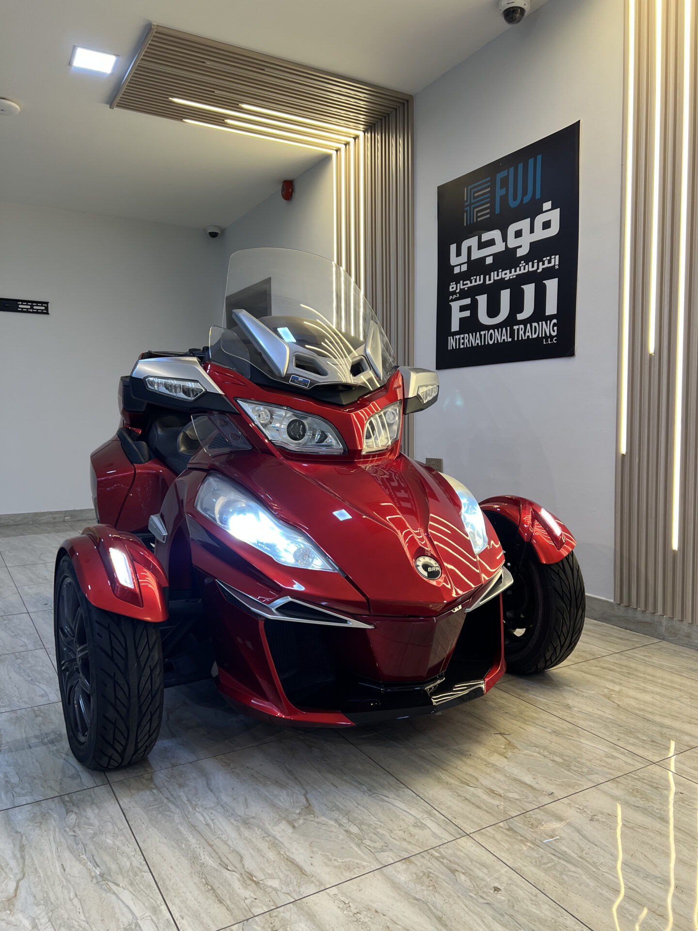 A 2015 Can-Am Spyder RT touring trike in glossy white with full touring fairings, large windscreen, comfortable passenger backrest, side panniers, and rear top case, parked outdoors with its three-wheel stance clearly visible.